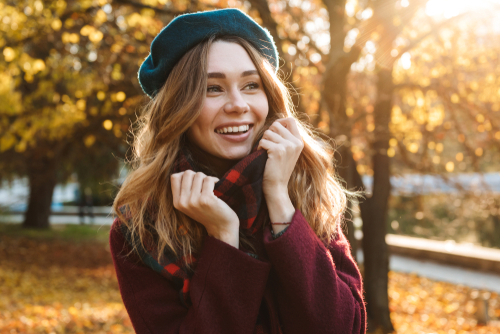 smiling woman wearing red jacket and green hat