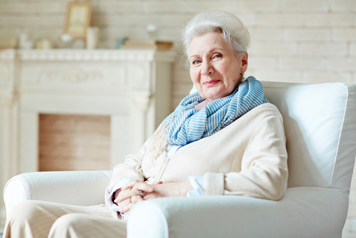 elderly woman sitting in a chair with a grin on her face
