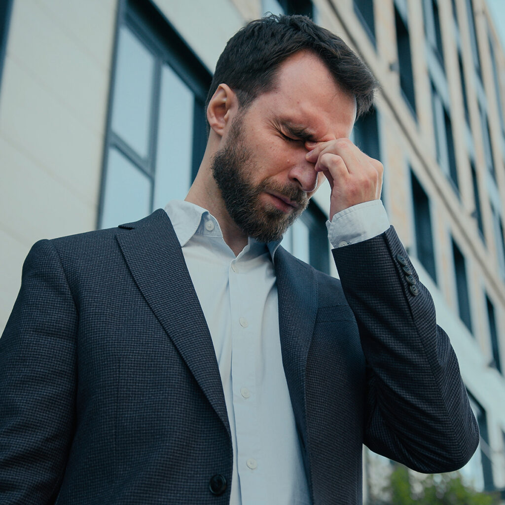 Man pressing the bridge of his nose in discomfort