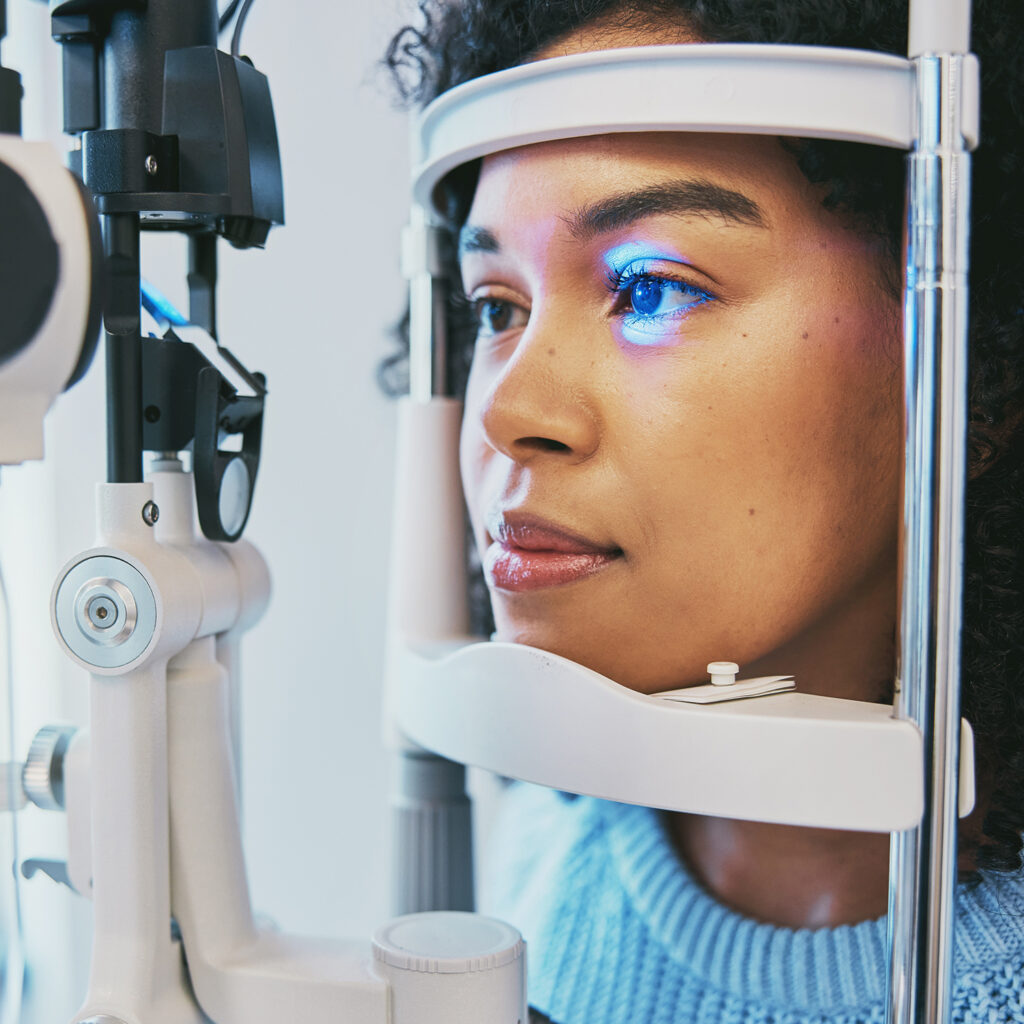Patient resting her chin on a slit lamp during an eye exam