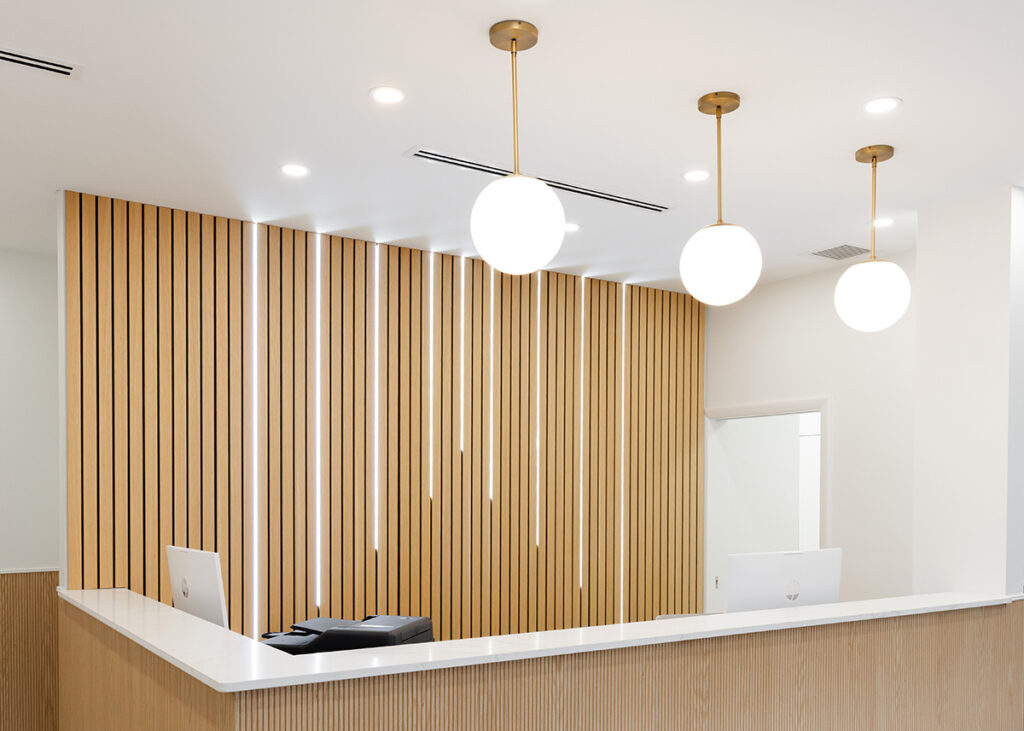 Reception area with a wood-slat wall and pendant lights